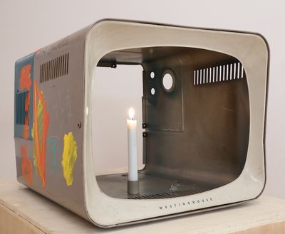 Nam June Paik, One Candle (also known as Candle TV) (2004). Cathode ray tube television casing with additions in permanent oil marker, acrylic paint, and live candle. Lent by the Estate of Nam June Paik.